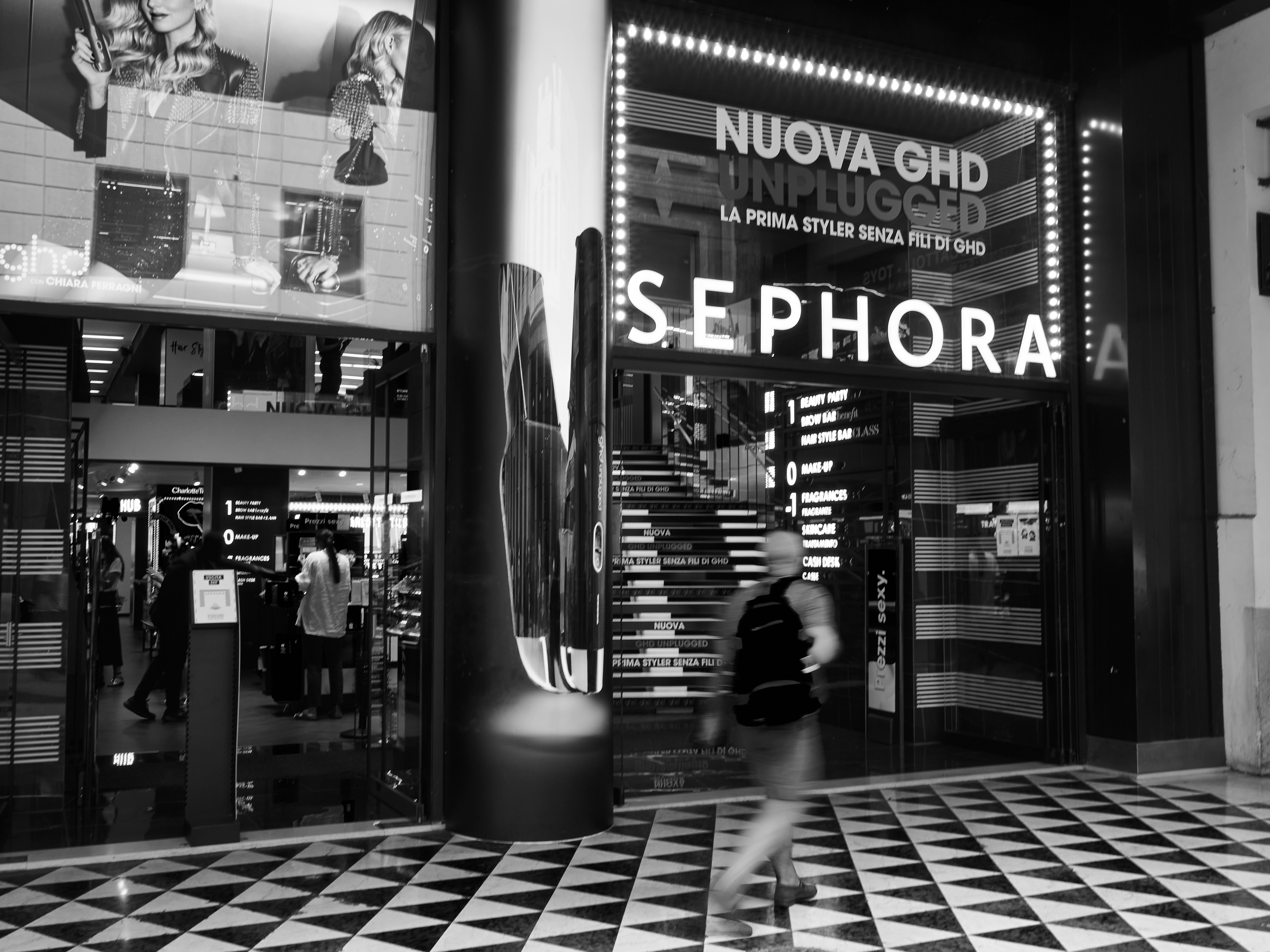 grayscale photo of people walking on sidewalk